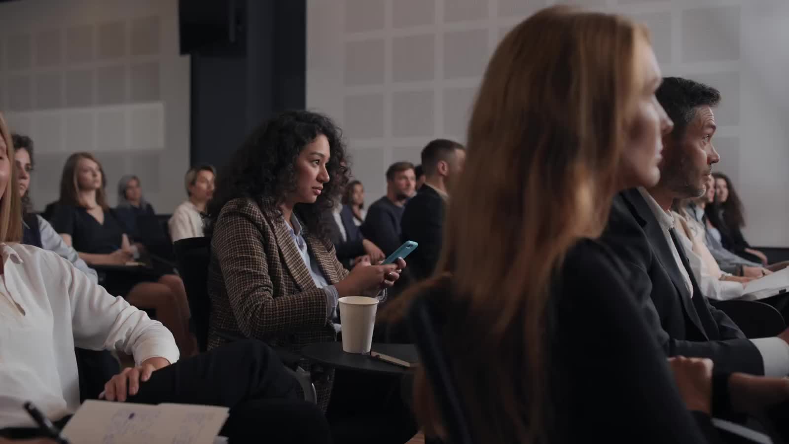 A professional audience listening closely at a conference